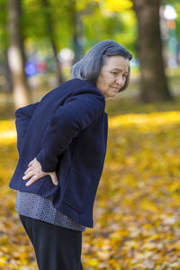 Side view of woman standing against trees