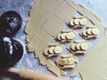 High angle view of banana on dough over kitchen counter