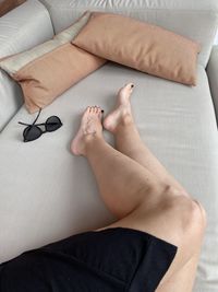 Low section of woman lying on bed at home