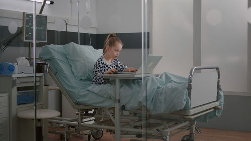 Midsection of woman using digital tablet while standing in hospital