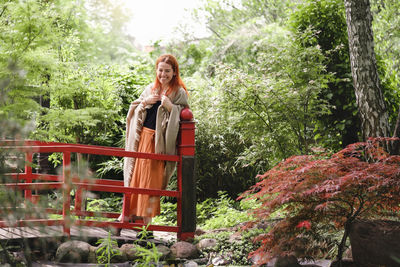 Happy ginger hair woman in well-groomed park or garden. freedom and healthy way of life. female in