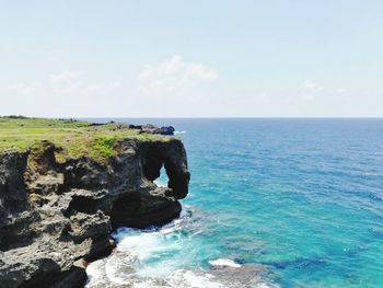 Scenic view of rocks on sea against sky