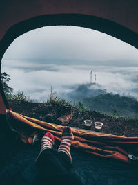 Low section on person in tent against sky during foggy weather
