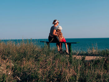 Friends on shore against sky