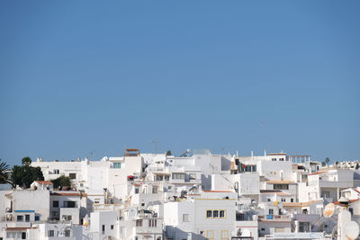 Buildings in town against clear blue sky