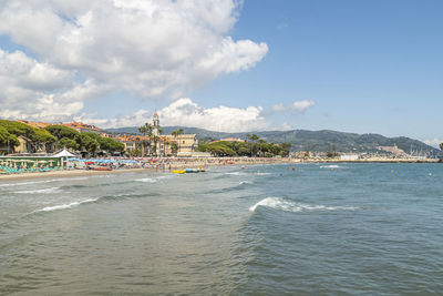 Scenic view of beach by city against sky