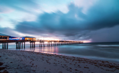 Scenic view of beach against sky at sunset