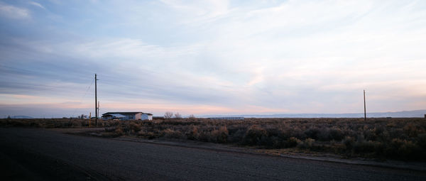 Road by land against sky during sunset