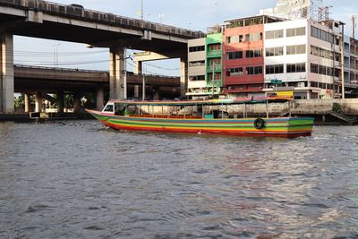 Boats moored on river against buildings in city