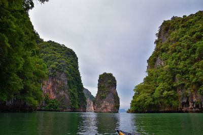 Scenic view of sea by mountains against sky