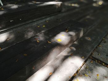 High angle view of sunlight falling on wet footpath