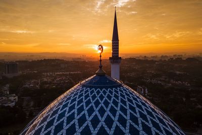 High section of mosque against sky during sunset