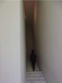 Rear view of man walking in corridor of building