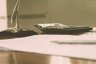 Close up of a calculator pen and paper placed on office desk.