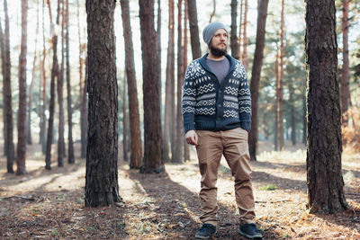 Full length of young man standing in forest