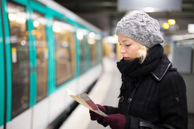 Young woman looking at camera while standing in illuminated winter