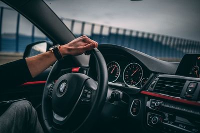 Midsection of man using mobile phone while sitting in car