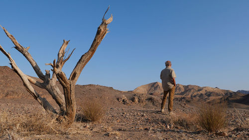 Rear view of senior man standing in the desert 