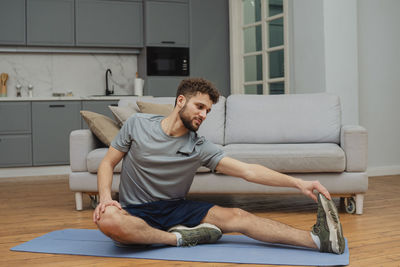 Portrait of young woman sitting on sofa at home