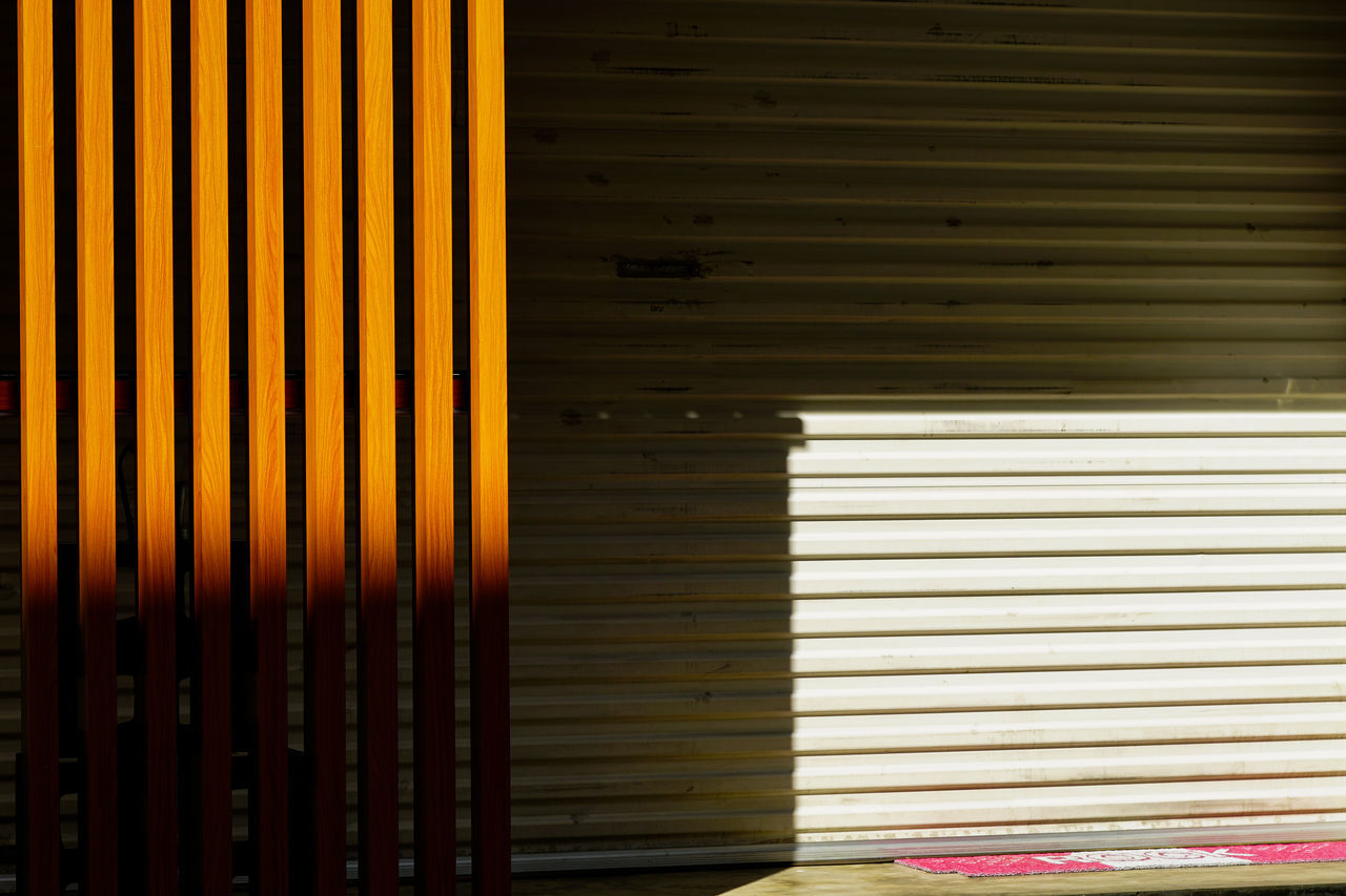 window covering, interior design, window blind, shutter, wood, no people, blinds, window treatment, corrugated iron, architecture, pattern, closed, iron, yellow, built structure, wall, sunlight, line, wall - building feature, day, light, striped, metal, full frame, backgrounds, corrugated, indoors, security, window
