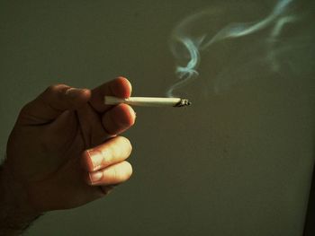 Close-up of man hand holding cigarette