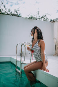 Woman sitting in swimming pool