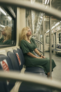 Full length of woman sitting in train