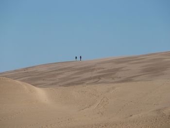Scenic view of desert against clear blue sky