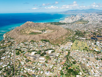 High angle view of townscape by sea against sky