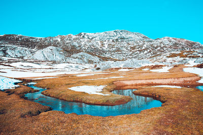 Scenic view of snowcapped mountains against clear blue sky