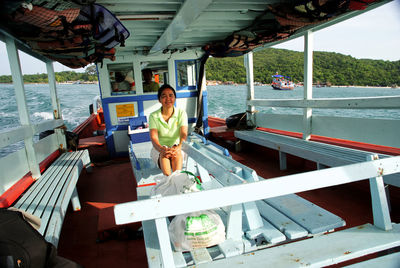 Young woman sitting on boat in sea