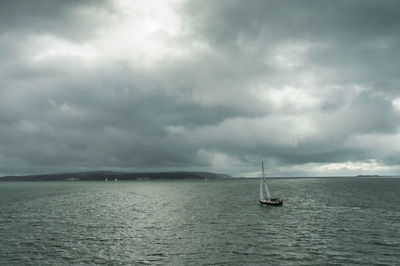 Sailboat sailing on sea against sky