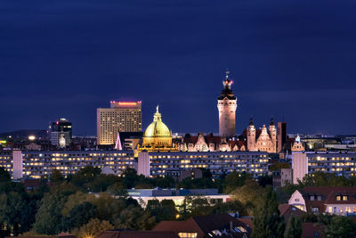 Illuminated buildings in city against sky at night