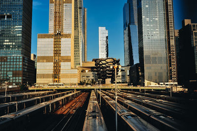 Railroad tracks amidst buildings in city against sky