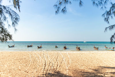 Sunny summer beach with boats on shore. phuket, thailand.