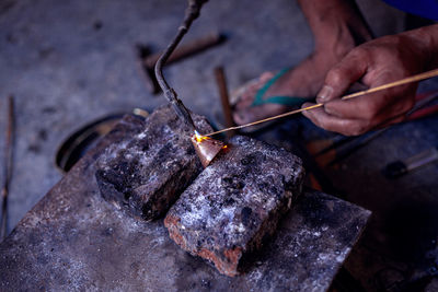 Cropped hand of person working on rock