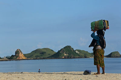 Man standing at beach against sky