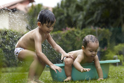 Siblings playing in water