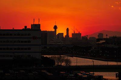 Silhouette buildings against sky during sunset