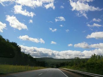 Empty road with trees in background