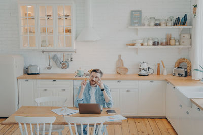 Woman sitting on table at home