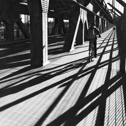 Rear view of person riding bicycle at high level bridge