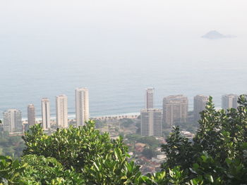 High angle view of buildings by sea against sky