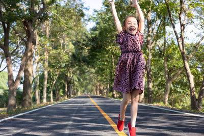 Portrait of young woman standing on road