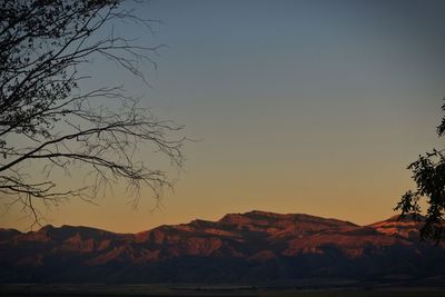 Scenic view of silhouette mountains against clear sky at sunset