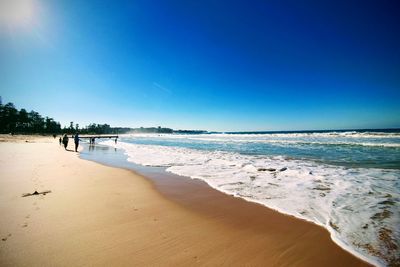 Scenic view of beach against clear blue sky