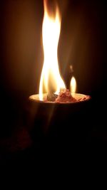 Close-up of lit candle in the dark