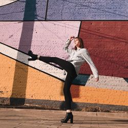 Full length of woman standing against colorful wall