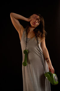 Woman standing against black background