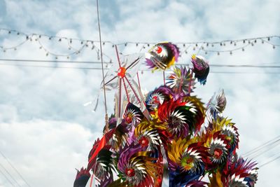 Low angle view of whirligigs against sky